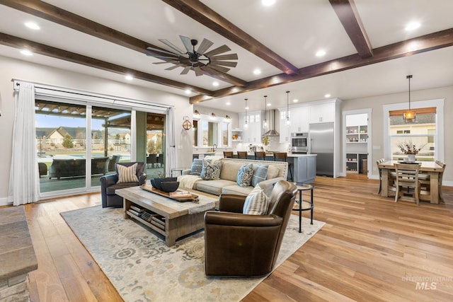 living room featuring recessed lighting, light wood-style flooring, beam ceiling, and ceiling fan