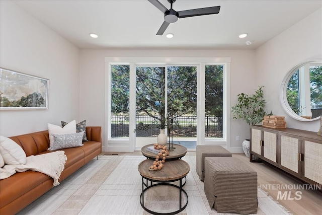 living area with recessed lighting, baseboards, a ceiling fan, and light wood finished floors