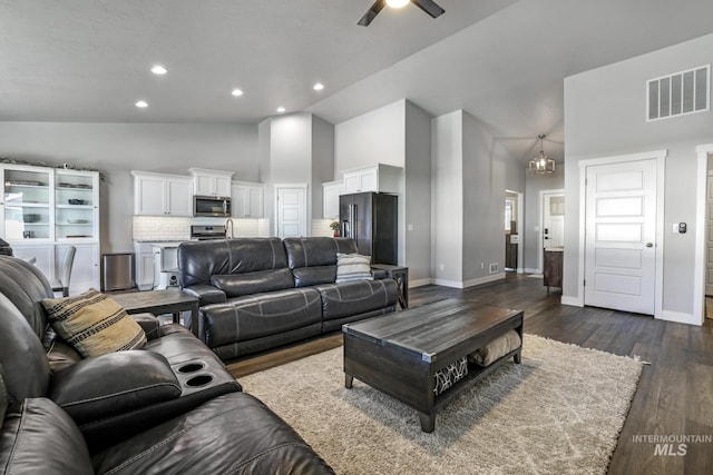 living room featuring recessed lighting, high vaulted ceiling, ceiling fan, dark wood-type flooring, and visible vents