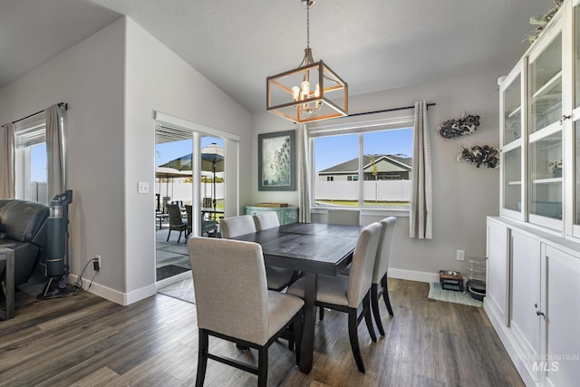 dining space with a healthy amount of sunlight, a notable chandelier, and dark wood finished floors