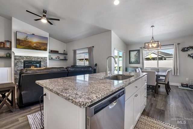 kitchen with plenty of natural light, vaulted ceiling, dishwasher, a sink, and dark wood-type flooring