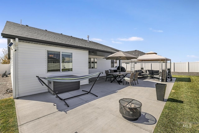 back of house featuring a gazebo, a patio area, outdoor dining area, roof with shingles, and fence