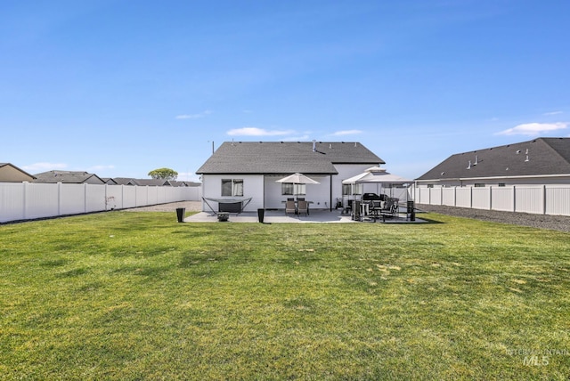 back of property featuring a patio, a fenced backyard, and a lawn
