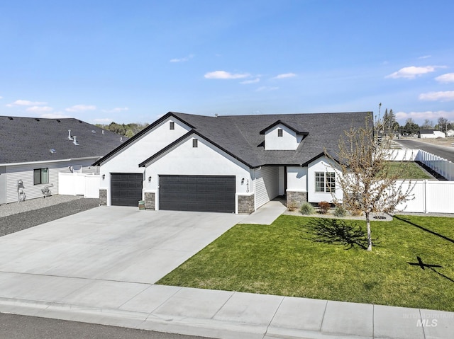 modern farmhouse featuring fence, a garage, driveway, stone siding, and a front lawn