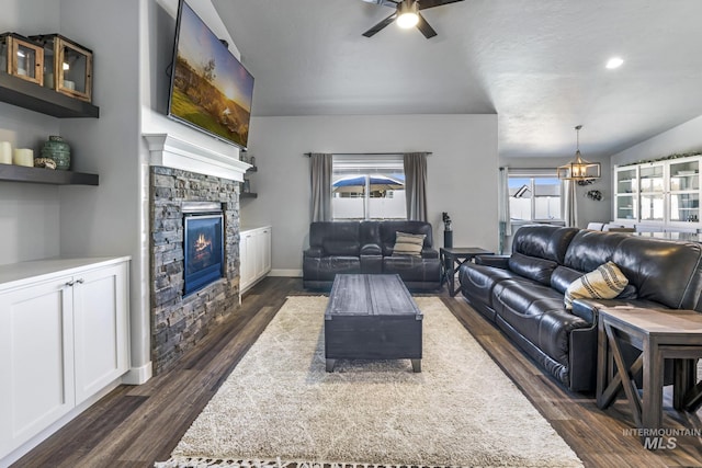 living area featuring recessed lighting, ceiling fan, a stone fireplace, and dark wood finished floors
