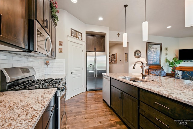 11771 W Cross Slope Way, Nampa, ID 83686 - kitchen featuring light wood-style flooring, light stone counters, stainless steel appliances, dark brown cabinets, and a sink