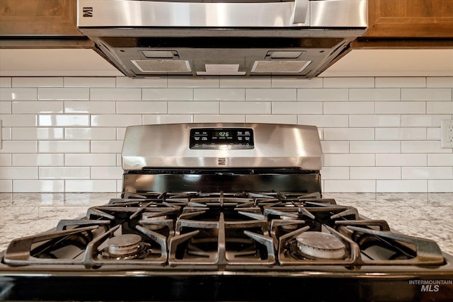11771 W Cross Slope Way, Nampa, ID 83686 - details with stainless steel gas stove, light stone counters, brown cabinetry, and decorative backsplash