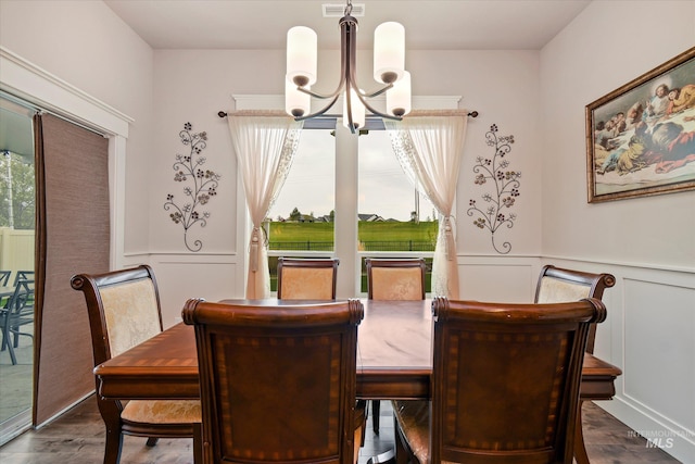 11771 W Cross Slope Way, Nampa, ID 83686 - dining room featuring an inviting chandelier, dark wood-type flooring, a wainscoted wall, visible vents, and a decorative wall