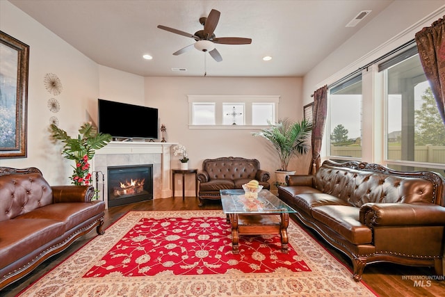 11771 W Cross Slope Way, Nampa, ID 83686 - living area with a tiled fireplace, ceiling fan, a wealth of natural light, and wood finished floors