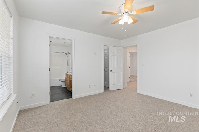 unfurnished bedroom featuring connected bathroom and light carpet