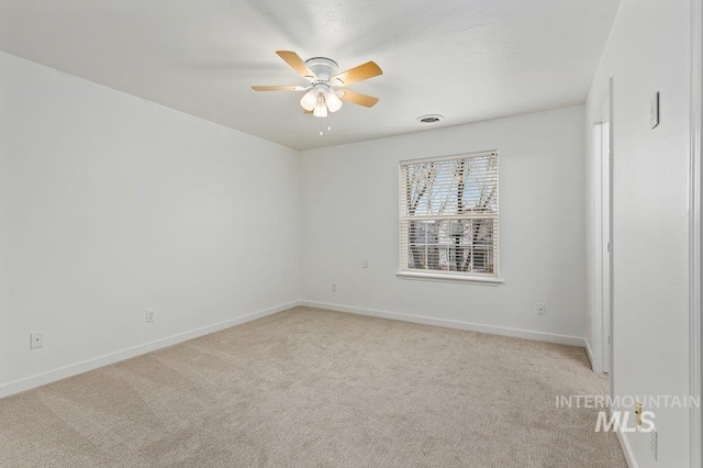 spare room featuring light carpet and ceiling fan