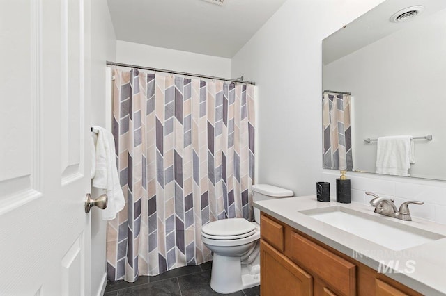 bathroom featuring tile patterned floors, toilet, and vanity