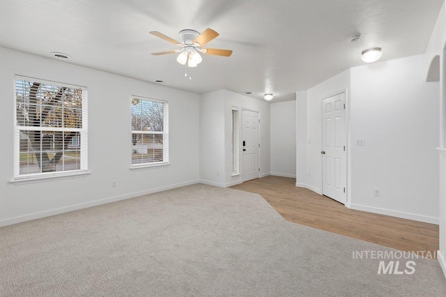 carpeted spare room with ceiling fan