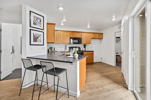 178 W Lava Falls Dr, Meridian, ID 83646 - kitchen featuring black microwave, dark countertops, a peninsula, recessed lighting, and stove