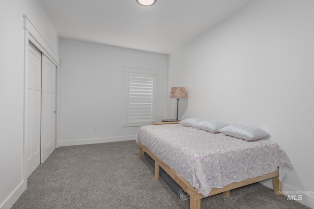 bedroom with carpet, baseboards, and a closet