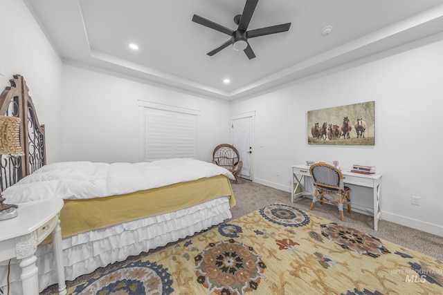 carpeted bedroom with a raised ceiling, recessed lighting, baseboards, and ceiling fan