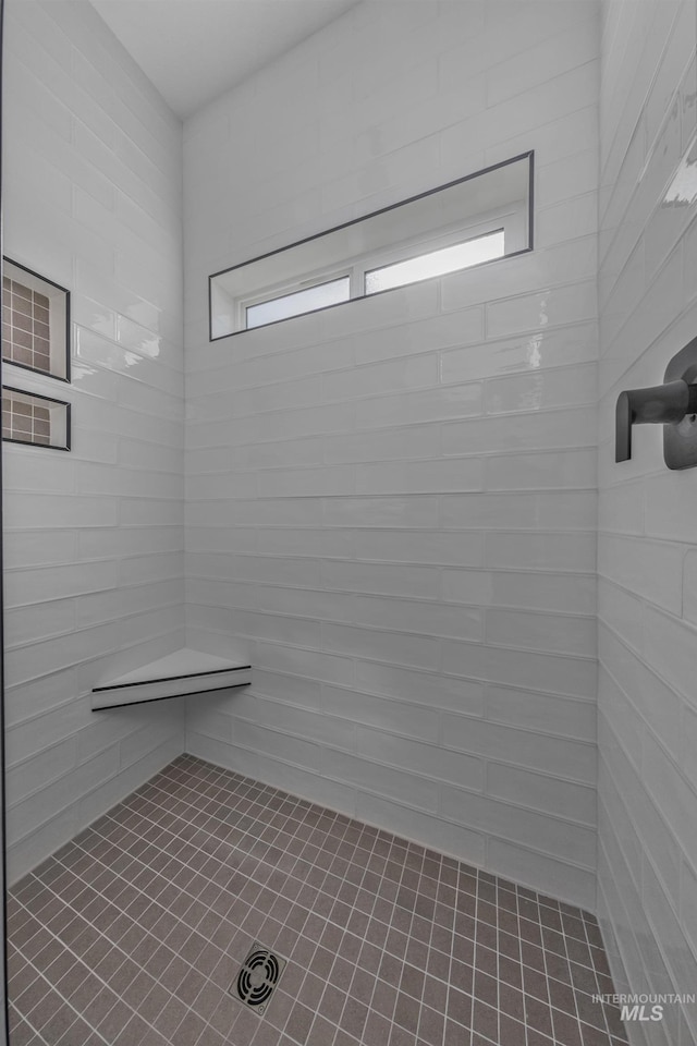 full bathroom featuring tiled shower and tile patterned flooring