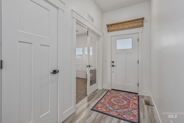 foyer entrance with light wood-type flooring and baseboards