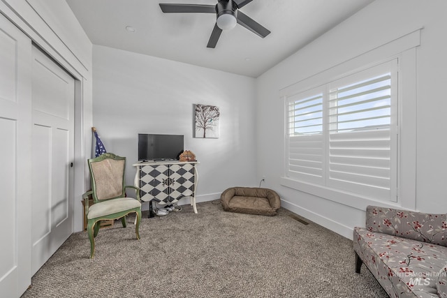 sitting room with carpet floors, a ceiling fan, and baseboards