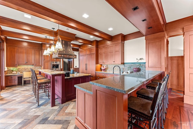 kitchen featuring a kitchen bar, kitchen peninsula, stainless steel oven, and hanging light fixtures