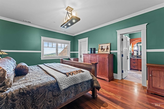 bedroom with crown molding and hardwood / wood-style flooring