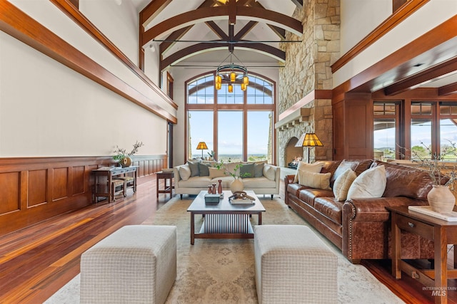 living room featuring hardwood / wood-style flooring, a wealth of natural light, beamed ceiling, and high vaulted ceiling