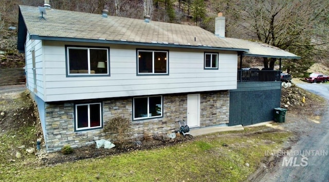 exterior space with stone siding and a chimney