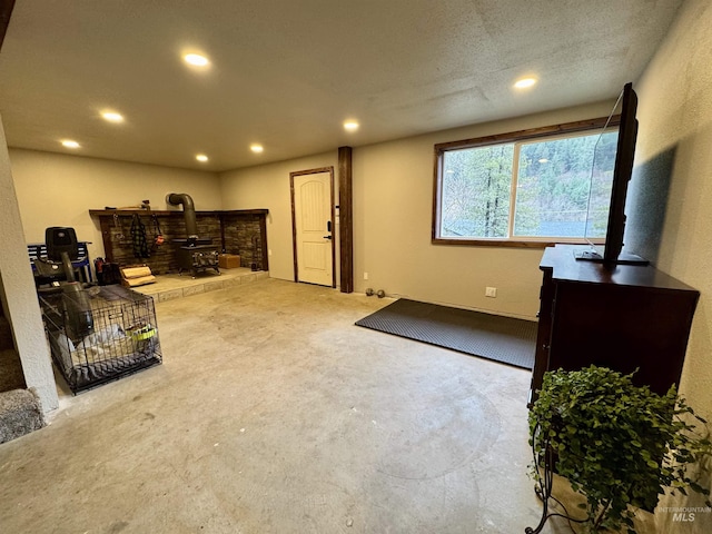 interior space featuring recessed lighting and a wood stove