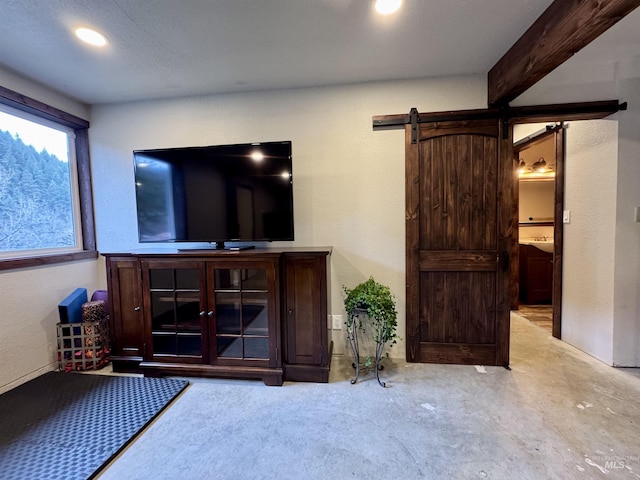 living room with concrete flooring and a barn door