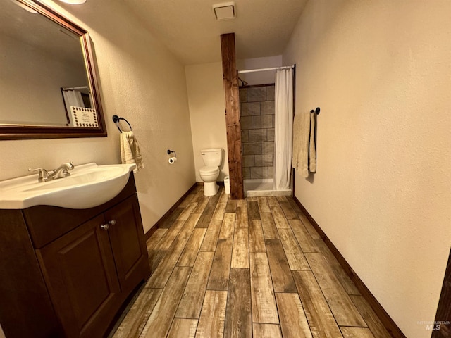 bathroom featuring toilet, wood finish floors, vanity, baseboards, and a shower with curtain