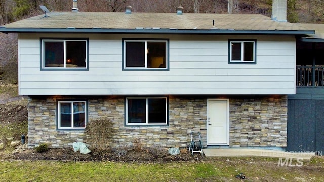 rear view of property with stone siding