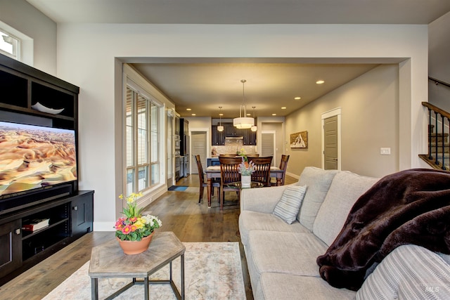 living room featuring recessed lighting, dark wood finished floors, baseboards, and stairs