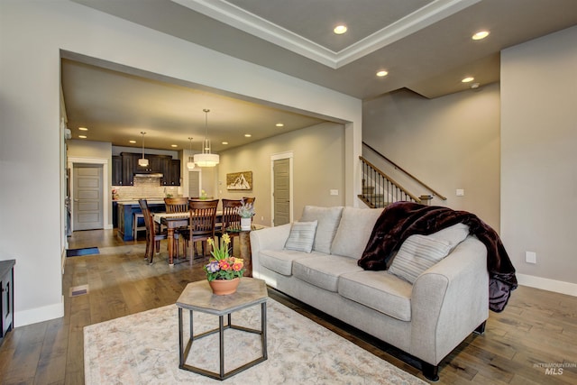 living room featuring dark wood-style floors, stairs, baseboards, and recessed lighting