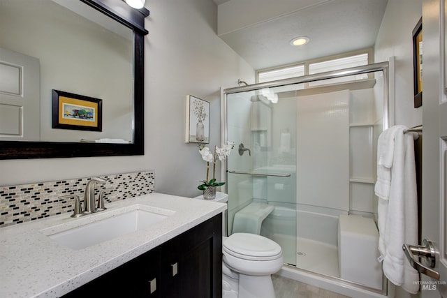 bathroom with toilet, a stall shower, tasteful backsplash, and vanity