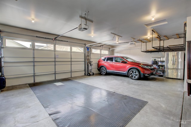 garage featuring a garage door opener and freestanding refrigerator