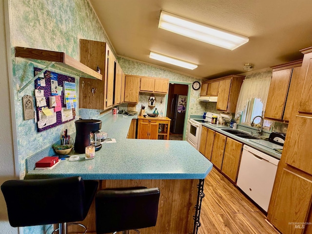 103 Beech St, Nezperce, ID 83543 - kitchen with lofted ceiling, white appliances, wallpapered walls, a sink, and light wood-style flooring