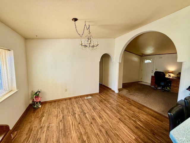 103 Beech St, Nezperce, ID 83543 - unfurnished dining area featuring arched walkways, wood finished floors, and visible vents