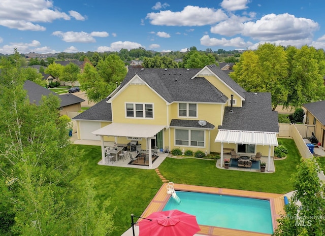 back of house with outdoor lounge area, a fenced in pool, a yard, an outdoor bar, and a patio