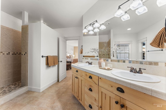 bathroom with tile patterned flooring, vanity, decorative backsplash, and tiled shower