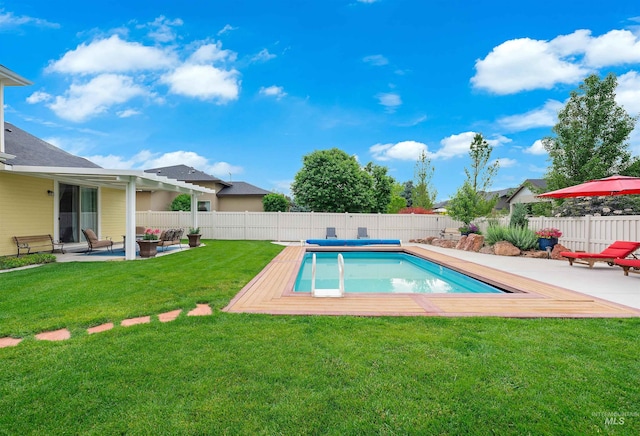 view of pool with a lawn and a patio