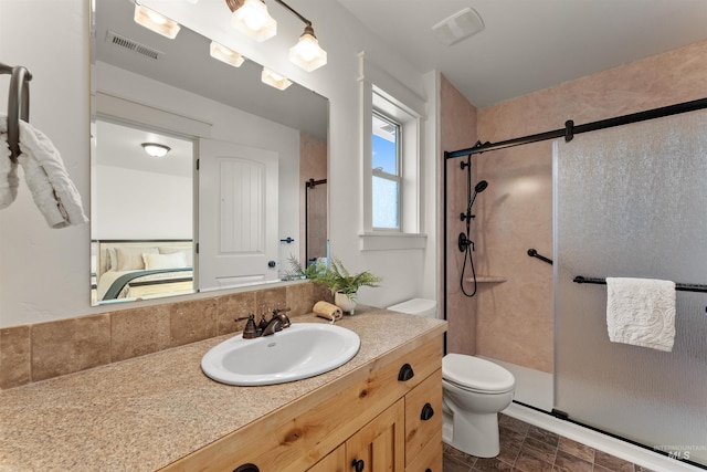 bathroom featuring toilet, a shower with door, and vanity