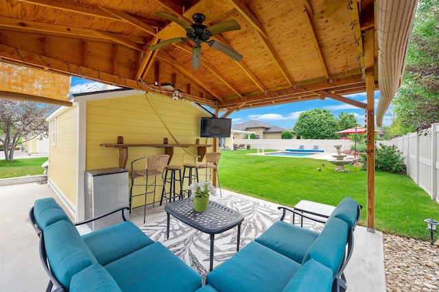 view of patio / terrace featuring ceiling fan, an outdoor bar, a fenced in pool, and an outdoor hangout area