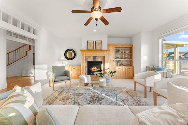 living room featuring ceiling fan and a fireplace