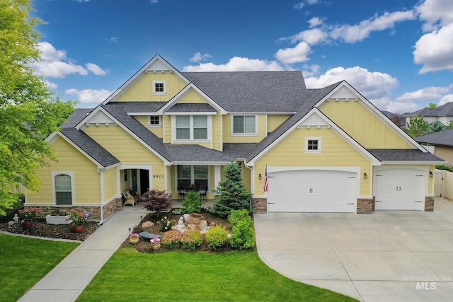 craftsman inspired home featuring a front yard and a garage