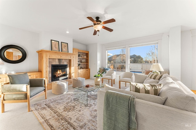 living room with ceiling fan, light colored carpet, and a fireplace