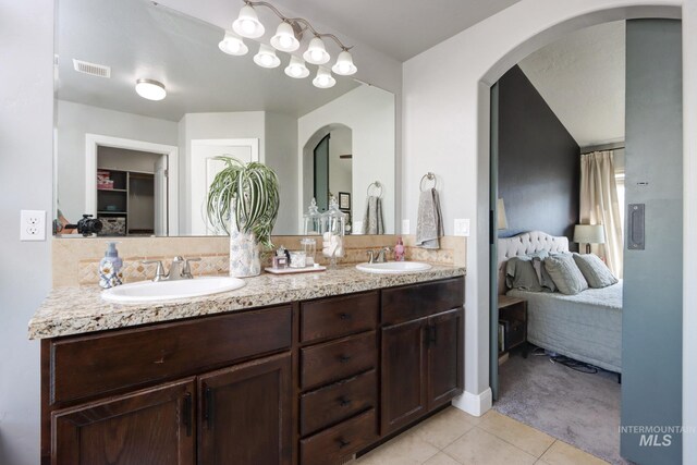 ensuite bathroom with tile patterned flooring and double vanity