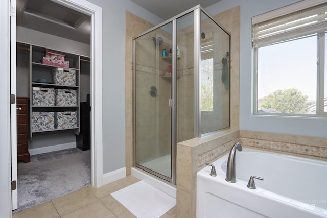 full bath featuring a stall shower, a spacious closet, tile patterned floors, and a bath