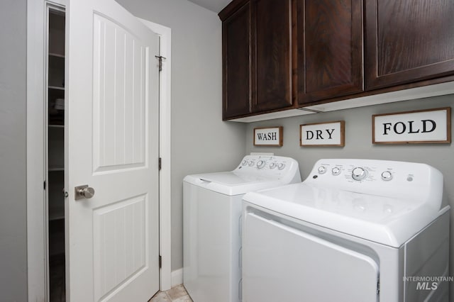 clothes washing area with cabinet space and separate washer and dryer