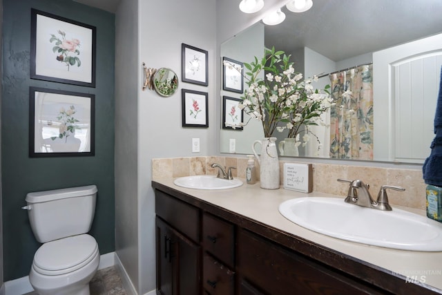 bathroom featuring toilet and double vanity