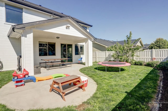 back of property featuring a trampoline and a patio area